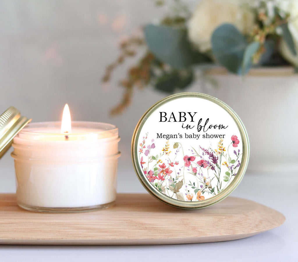 Eco-friendly Baby in Bloom wildflower baby shower favor candle on a wooden tray with a lit candle.